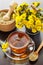 Healthy tea, bucket with coltsfoot flowers and mortar on table
