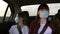 Healthy teenage girls in protective sterile medical mask ride in a taxi. The concept of a pandemic coronavirus. Free