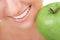 Healthy teeth and green apple. Smiling woman mouth with great white teeth. Close up. Beauty and dental health. Pretty woman