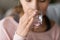 Healthy thirsty young woman holding glass drinking water, close up