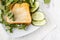 Healthy toast with goats cheese, avocado, arugula and sun dried tomatoes on rustic wooden table