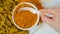Healthy turmeric spice powder in spoon macro on white background, top view slow motion.