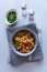 Healthy vegan bowl with quinoa, pumpkin, pepper and carrot on gray wooden background. Selective focus