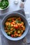 Healthy vegan bowl with quinoa, pumpkin, pepper and carrot on gray wooden background. Selective focus