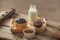 Healthy vegan breakfast. Bottled milk with chia, almond, fresh fruit and berries over wooden table background, copy space. Clean