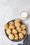 Healthy vegan cookies with nuts and raisin on a ceramic plate with milk, grey concrete background.