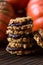 Healthy vegan dessert. Pile of homemade pumpkin oatmeal breakfast cookie sandwiches with dark chocolate and winter squashes on oak