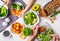 Healthy vegan food lunch, top view. Vegetarian dinner table, people eat healthy food. Salad, sweet potato, vegan cake, vegetables