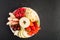 Healthy vegan fruit snack in bowl. Apple, strawberries, raspberries, peaches, cherry, banana on white plate. Flat lay style