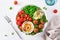 Healthy vegan lunch bowl with falafel hummus tomato avocado peas