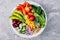 Healthy vegan lunch Buddha bowl. Avocado, quinoa, tomato, cucumber, red beans, spinach, red onion and red paprika vegetables salad