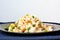 Healthy vegan meal with rice, chickpeas, sweet corn, peas, green beans and rice on dark plate on jeans cloth on wooden background