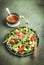 Healthy vegan salad with arugula, avocado, juicy grapefruit, cashews and dressing with olive oil, honey and wine vinegar. Green