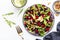 Healthy vegan salad with beetroot, prunes, arugula, chard and walnuts, white table background. Fresh useful vegetarian dish for