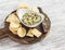 Healthy vegetarian broccoli and pine nuts hummus and homemade cheese biscuits on a wooden rustic board.