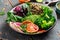 Healthy vegetarian buddha bowl salad with vegetables, avocado, blood orange, broccoli, watermelon radish, spinach, quinoa, pumpkin