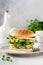 Healthy Vegetarian burger with egg and pea shoots and seeds microgreen, fresh salad, cucumber slice on a cutting wooden board on l