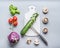 Healthy vegetarian clean food concept with vegetables cooking ingredients: cutting board and knife on gray background, top view