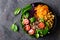 Healthy vegetarian dish with buckwheat and vegetable salad of chickpea, kale, carrot, fresh tomatoes, spinach leaves and pine nuts