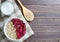 Healthy vegetarian food. Oatmeal with raspberry. Wooden spoon with cereals. Brown wooden background. Copy space