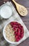 Healthy vegetarian food. Oatmeal with raspberry. Wooden spoon with cereals. Brown wooden background. Flat Lay. Vertical photo