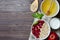 Healthy vegetarian food. Oatmeal with raspberry. Wooden spoon with cereals, milk in a glass, apple. Brown wooden background. Flat