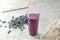 Healthy vegetarian food, purple smoothies in a long glass mug on a light background and scattered berries