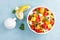 Healthy vegetarian fresh fruit salad with apple, pear, tangerine, grapefruit, mango, pomegranate and lemon juice. Top view