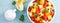Healthy vegetarian fresh fruit salad with apple, pear, tangerine, grapefruit, mango, pomegranate and lemon juice. Top view. Banner