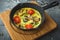 Healthy vegetarian omelet in frying pan and pumpkin seeds on wooden board