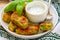 Healthy vegetarian potato patties with carrots, broccoli, bell pepper, green peas and onions with sour cream sauce with dill and