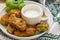 Healthy vegetarian potato patties with carrots, broccoli, bell pepper, green peas and onions with sour cream sauce with dill and