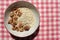 Healthy Walnut Oatmeal in vintage bowl on a red and white checkered cloth napkin. Natural lighting.