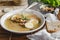 Healthy and warming winter soup with rice, carrot, chickpeas, chicken, ham and boiled egg over rustic background.