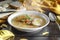 Healthy and warming winter soup with rice, carrot, chickpeas, chicken, ham and boiled egg over rustic wooden table background