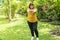 Healthy weight loss concept. Happy overweight young woman stretching before workout in the garden. Fat girl obesity stretch arm