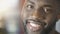 Healthy white smile of excited African American man looking into camera, closeup