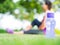 Healthy woman athlete is resting on grass. Focus on bottle of water.