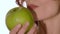 Healthy woman eating an apple, close up