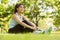 Healthy woman relaxing in park as she ties shoelace