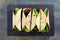 Healthy wraps with beet hummus, avocado and spinach, above view on slate