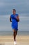 Healthy young african man jogging along the beach