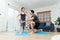 Healthy young Asian couple exercises in home and husband teaching him a wife for exercise in COVID-19 quarantine at home. A new