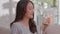 Healthy Young Asian woman Drinking milk with calcium for strong bone at home,Smiling indian woman holding soy milk on glass enjoy