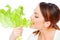 Healthy young woman eating green lettuce