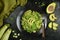 Healthy Zucchini Noodles with Basil Pesto, Beans, Brussels Sprouts and Avocado - served on a black background