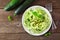 Healthy zucchini pasta topped with garlic and basil, top view table scene over rustic wood