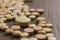 Heap of assorted beige capsules on wooden table.