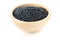 Heap of black organic beluga lentils in wooden bowl on white