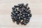 Heap of black shell nuts on wooden background.